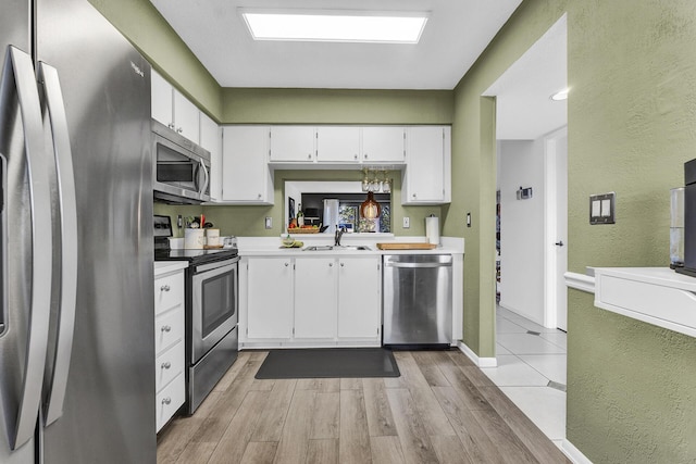 kitchen with sink, white cabinetry, and appliances with stainless steel finishes