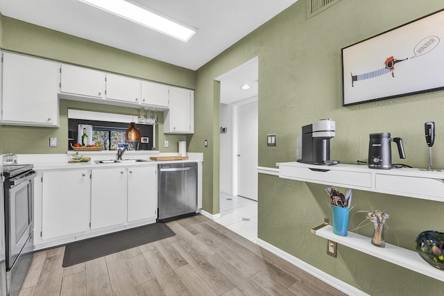 kitchen featuring white cabinets, sink, stainless steel appliances, and light hardwood / wood-style flooring