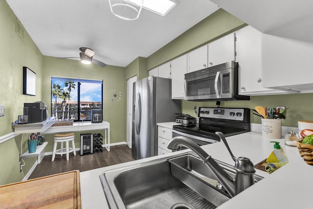 kitchen featuring white cabinetry, ceiling fan, stainless steel appliances, dark hardwood / wood-style flooring, and sink