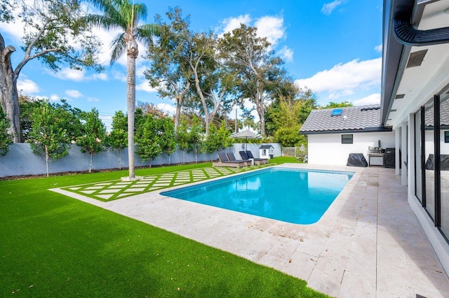 view of swimming pool with a yard and a patio