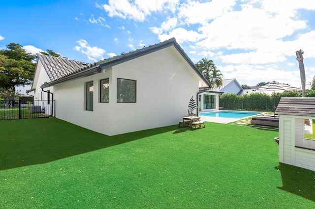 back of property featuring a lawn and a fenced in pool