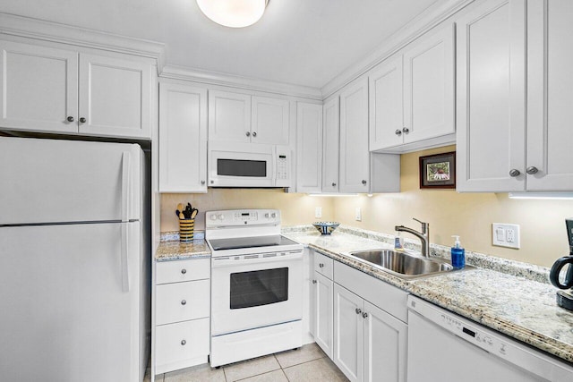 kitchen with white cabinets, white appliances, sink, and light tile patterned floors