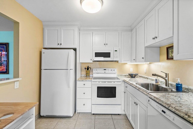 kitchen with light stone countertops, white appliances, sink, light tile patterned floors, and white cabinets