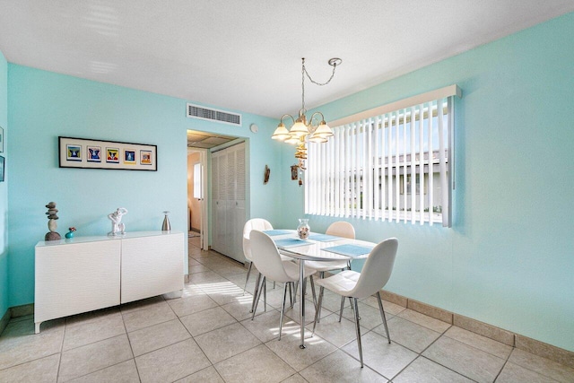 tiled dining space with a chandelier