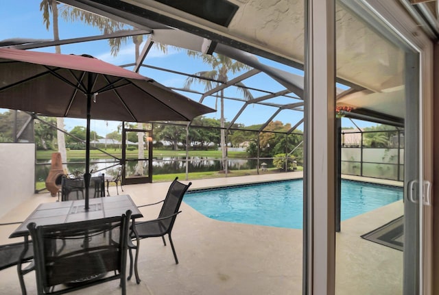 view of pool with a lanai, a water view, and a patio