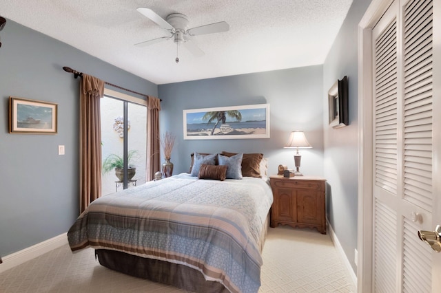 carpeted bedroom featuring ceiling fan, access to exterior, a textured ceiling, and a closet