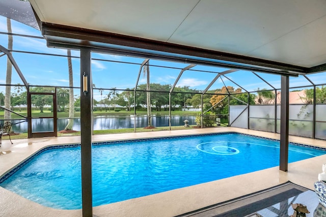 view of swimming pool with glass enclosure, a water view, and a patio