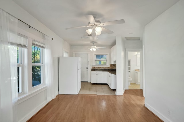 kitchen featuring white refrigerator, white cabinets, ceiling fan, light hardwood / wood-style floors, and backsplash