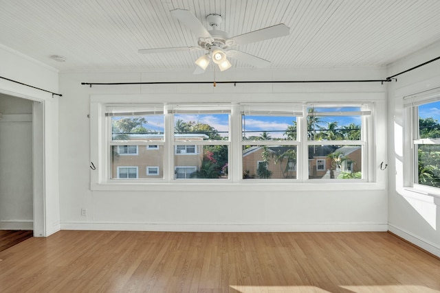 unfurnished sunroom featuring ceiling fan and a healthy amount of sunlight