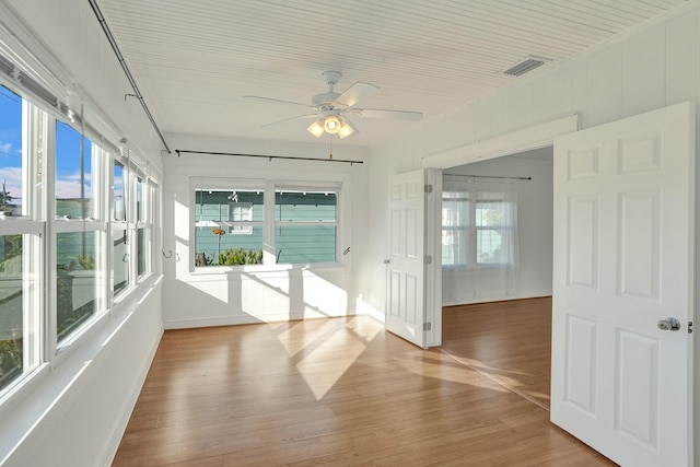 unfurnished sunroom with ceiling fan