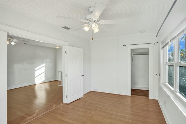 unfurnished bedroom featuring ceiling fan, hardwood / wood-style floors, and a closet