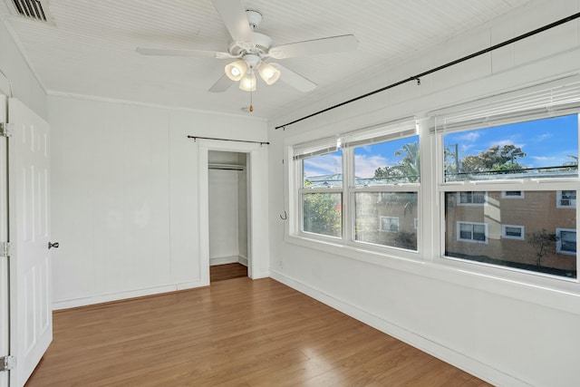 unfurnished bedroom featuring ceiling fan, a closet, and hardwood / wood-style floors