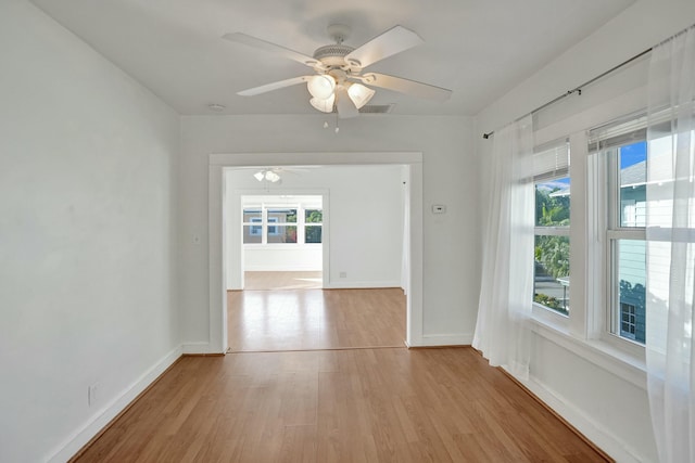 unfurnished room with light wood-type flooring, ceiling fan, and a wealth of natural light