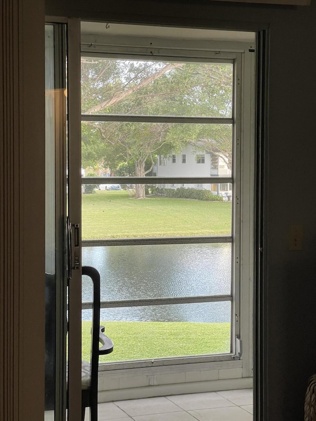 doorway featuring light tile patterned floors and a water view