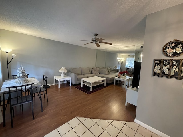 living room featuring a textured ceiling, ceiling fan, and hardwood / wood-style flooring