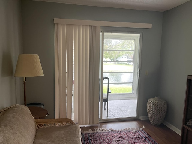 doorway to outside featuring hardwood / wood-style flooring and a water view