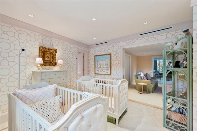 bedroom featuring light carpet, crown molding, and a nursery area