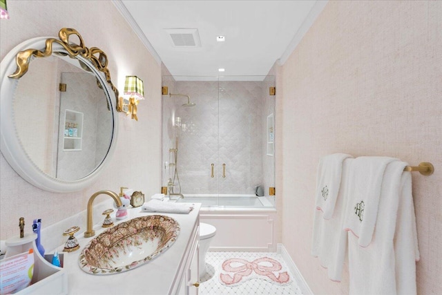 full bathroom featuring vanity, tile patterned floors, combined bath / shower with glass door, crown molding, and toilet