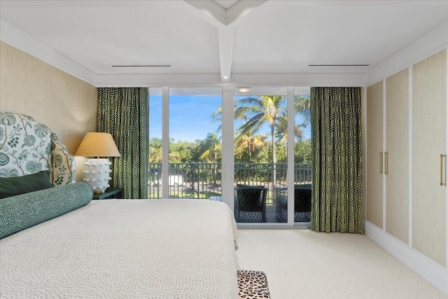 bedroom with expansive windows, crown molding, and access to outside