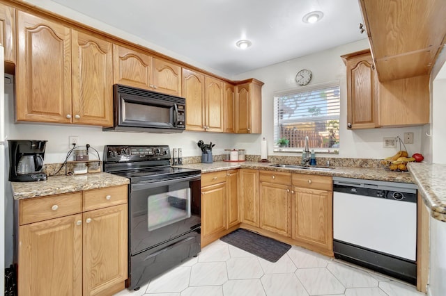 kitchen with light stone countertops, sink, and black appliances