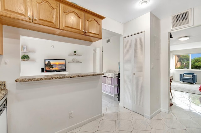 kitchen with light stone counters, dishwasher, and light tile patterned floors