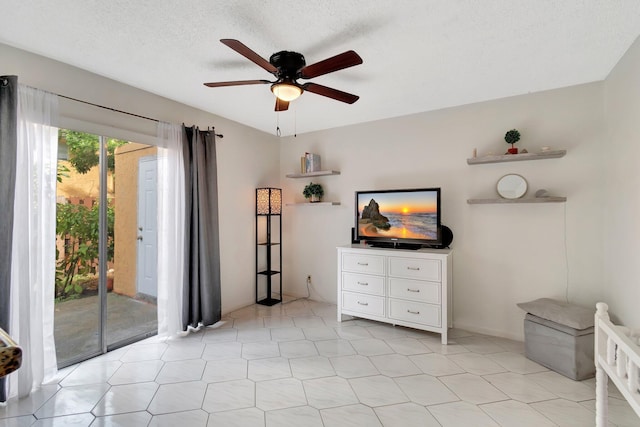 interior space with a textured ceiling and ceiling fan