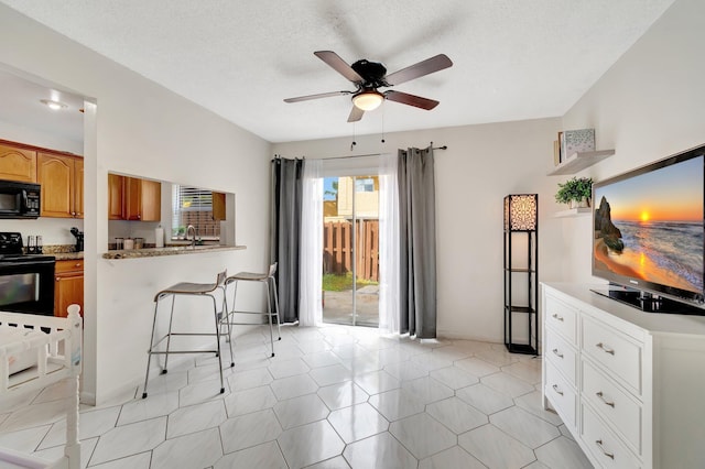 interior space featuring light tile patterned flooring, a textured ceiling, ceiling fan, and sink