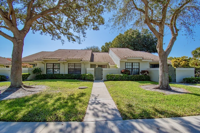 mediterranean / spanish-style home featuring a front yard