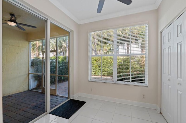 entryway with baseboards, ceiling fan, and crown molding