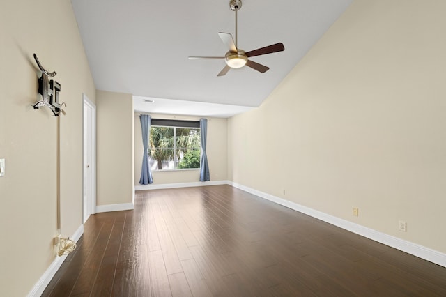 empty room with vaulted ceiling, baseboards, dark wood finished floors, and a ceiling fan