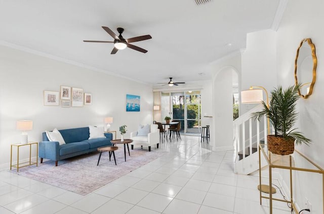 living area featuring baseboards, ornamental molding, arched walkways, and light tile patterned flooring