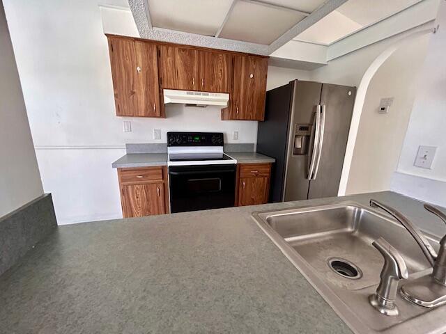 kitchen with stainless steel fridge, sink, and electric stove