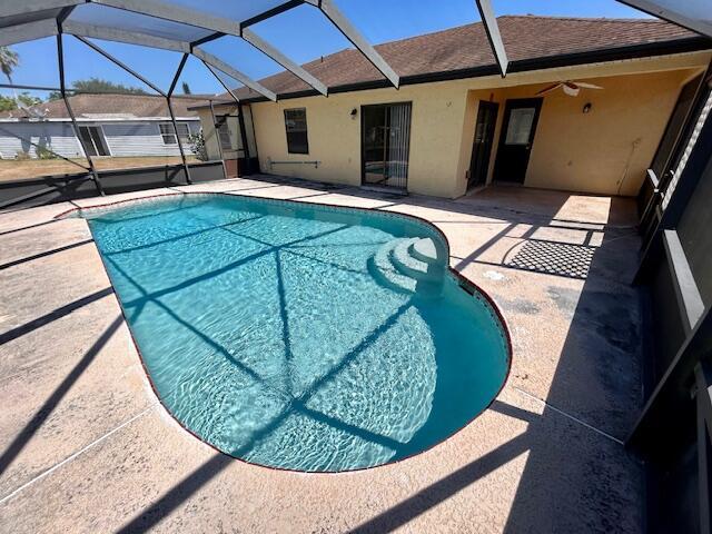 view of pool with a lanai, a patio area, and ceiling fan