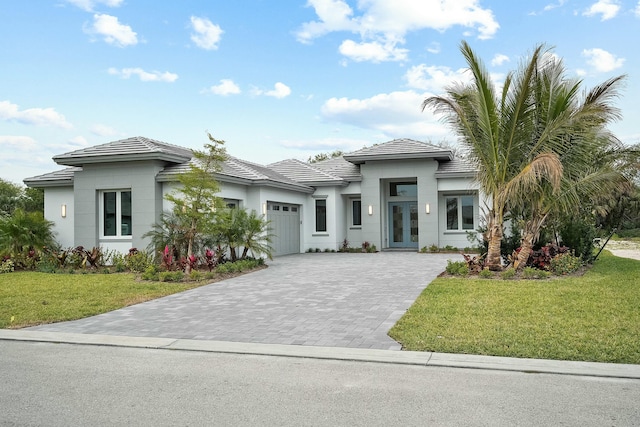 view of front of home featuring french doors, a front lawn, and a garage