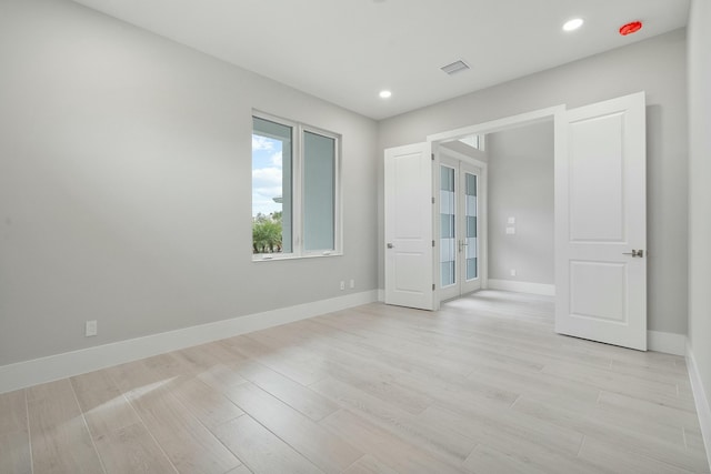 empty room with french doors and light wood-type flooring