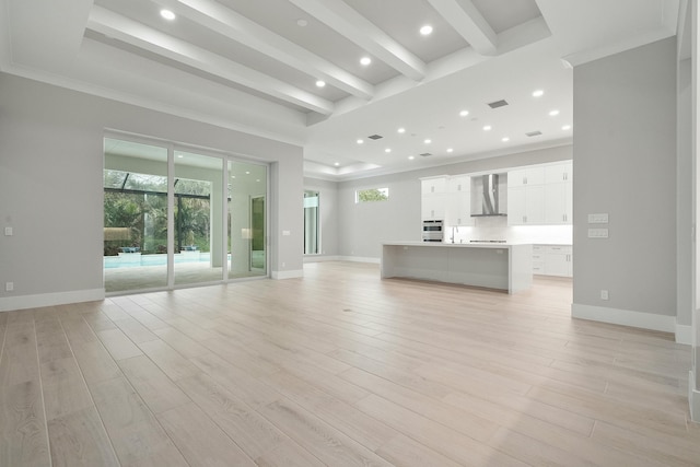 unfurnished living room with crown molding and light hardwood / wood-style flooring