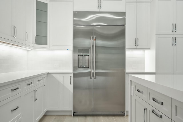 kitchen with tasteful backsplash, white cabinetry, and stainless steel built in fridge