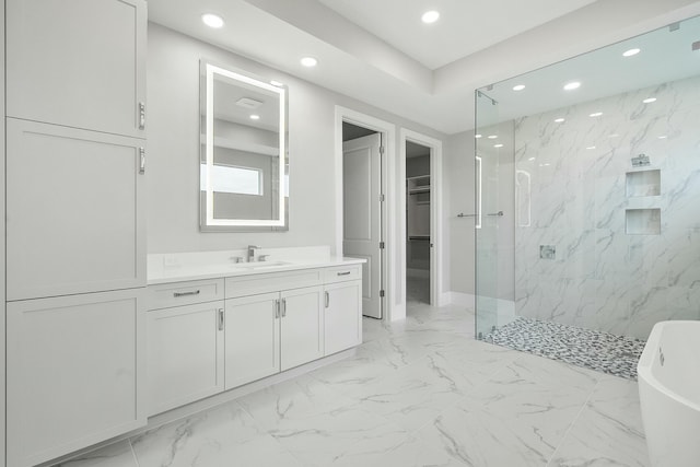 bathroom with vanity and shower with separate bathtub