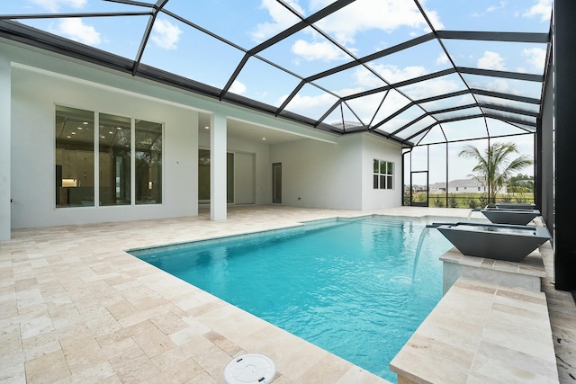 view of pool featuring pool water feature, a patio, and glass enclosure