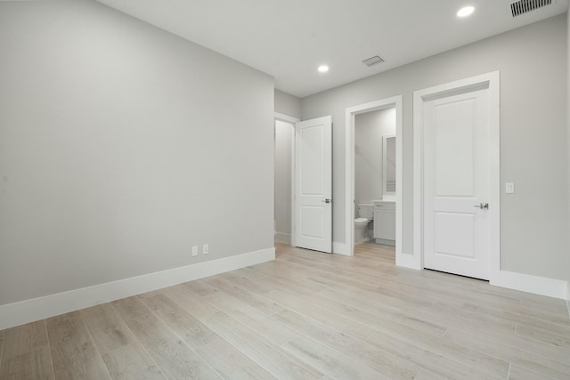 unfurnished bedroom with connected bathroom and light hardwood / wood-style flooring