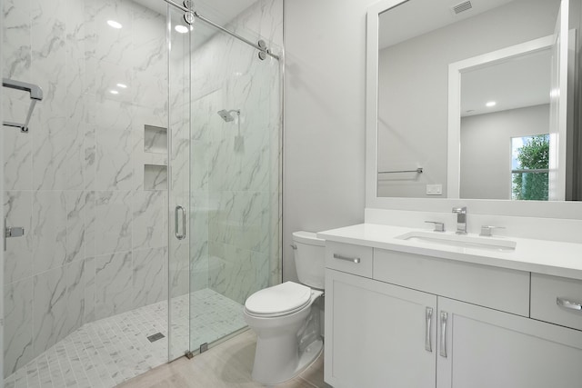 bathroom with vanity, an enclosed shower, and toilet