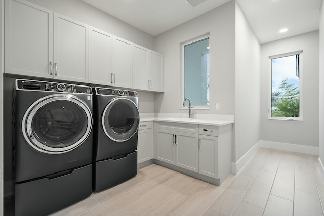 laundry room featuring sink, cabinets, and independent washer and dryer