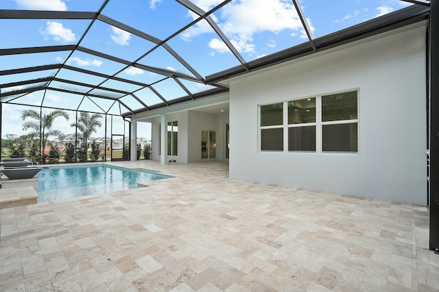 view of swimming pool featuring glass enclosure and a patio