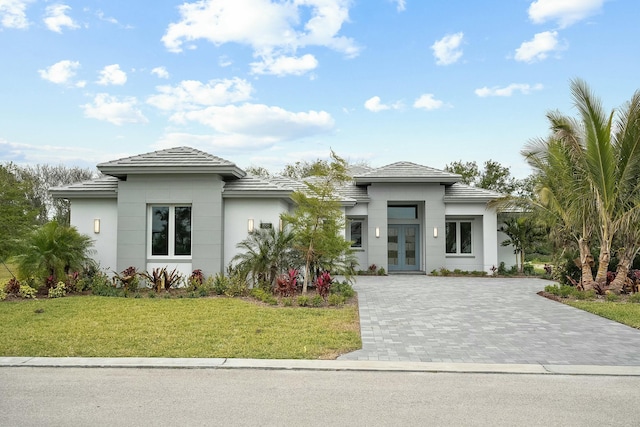 prairie-style house featuring a front lawn and french doors