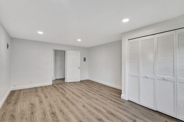 unfurnished bedroom featuring a closet and light wood-type flooring