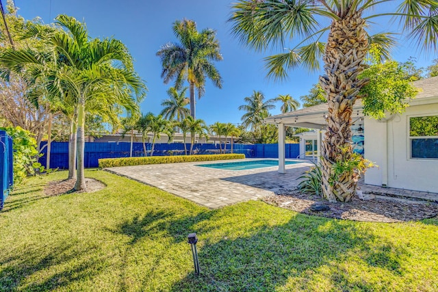 view of property's community with a yard, a swimming pool, and a patio