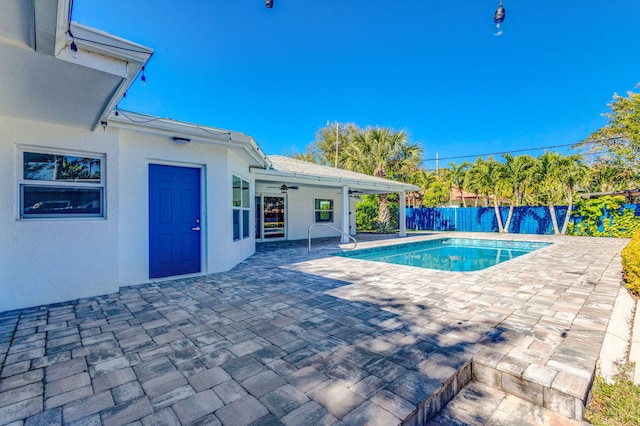 view of pool featuring a fenced in pool, fence, a patio, and a ceiling fan