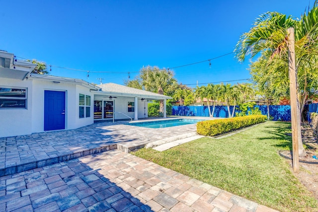 view of swimming pool with a fenced in pool, a yard, a patio, a ceiling fan, and fence