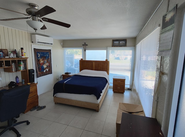 tiled bedroom with a textured ceiling, ceiling fan, and a wall mounted air conditioner