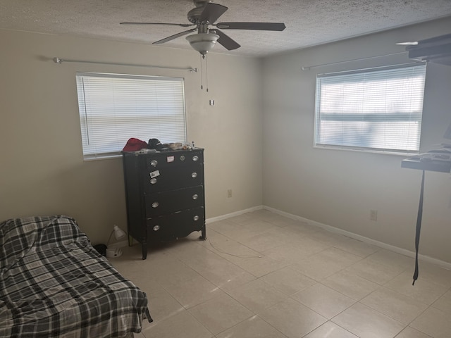 bedroom featuring light tile patterned floors, a textured ceiling, and ceiling fan